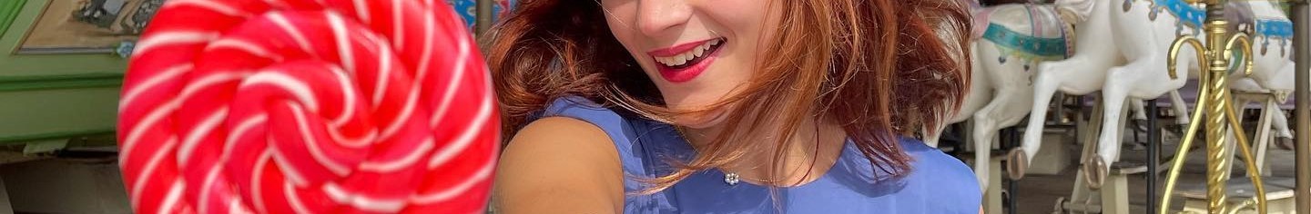 young lady enjoying a lollipop with a smile